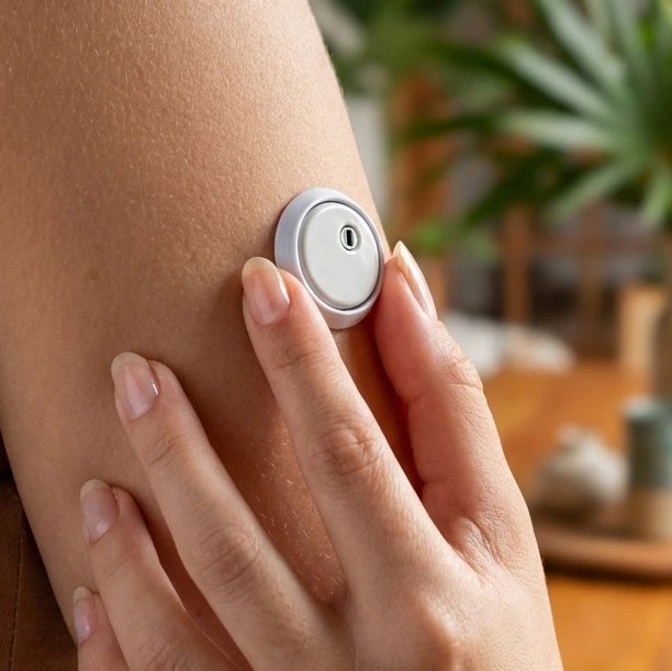 Adesivo protetor de sensor sendo aplicado no braço